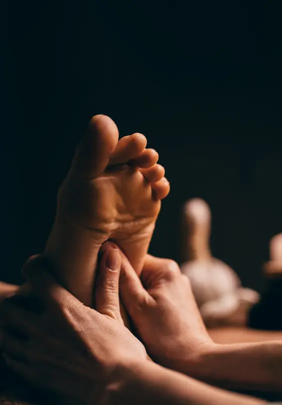 Customer's foot is held by highly qualified reflexology specialist, and the client's key pressure points are being massaged and stimulated
